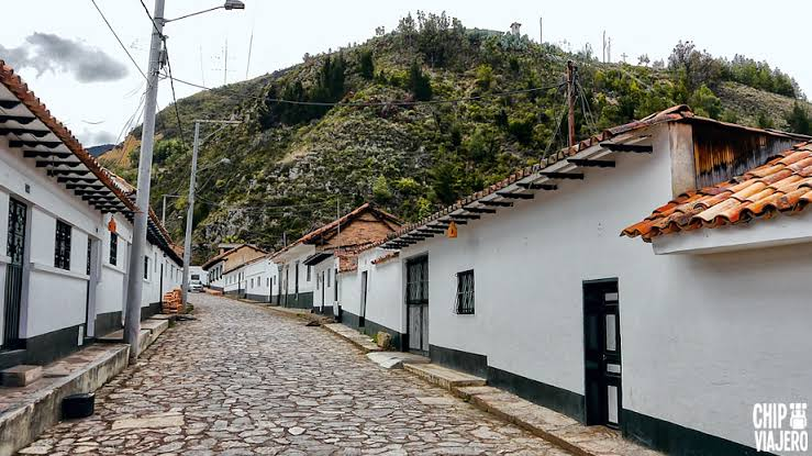 Calle empedrada con casas blancas y techos de teja en Cucunubá